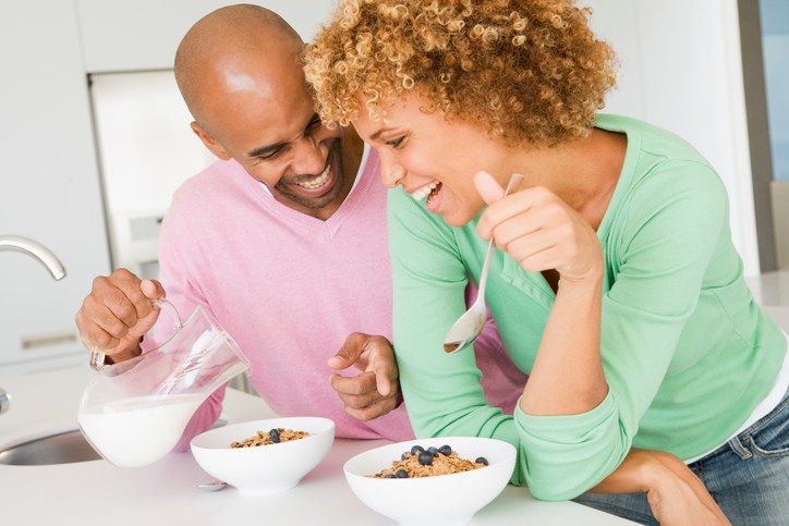 African American couple eating cereal breakfast