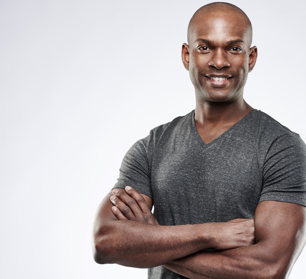 African American man smiling with arms folded