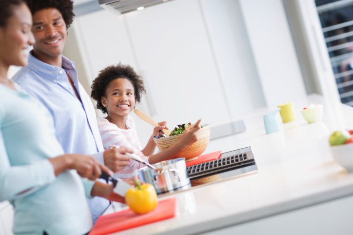 African American Black family in kitchen meal prepping 