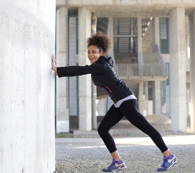 African American Black woman stretching exercise outdoors leggings