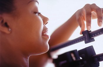 A close-up of a woman weighing herself 