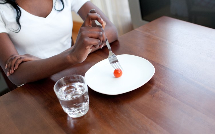 Teen girl eating a tomato