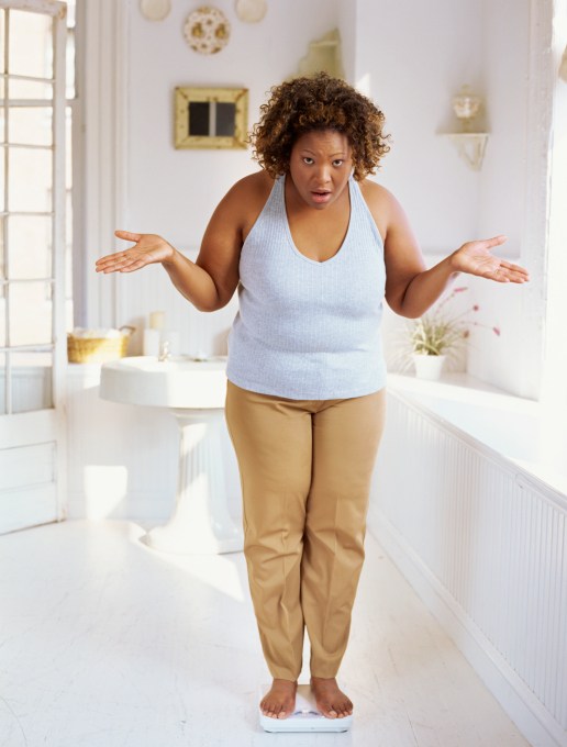 woman standing on scale in disbelief