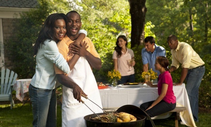 black couple grilling outside with friends