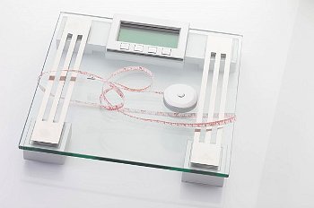 Weight loss tools, including a clear glass scale and a tape measure