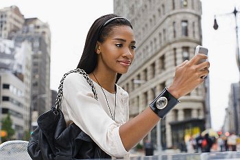 A woman texting on her cell phone while walking down the street