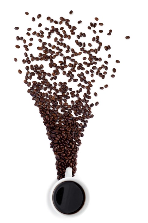 scattered coffee beans leading to a cup of coffee