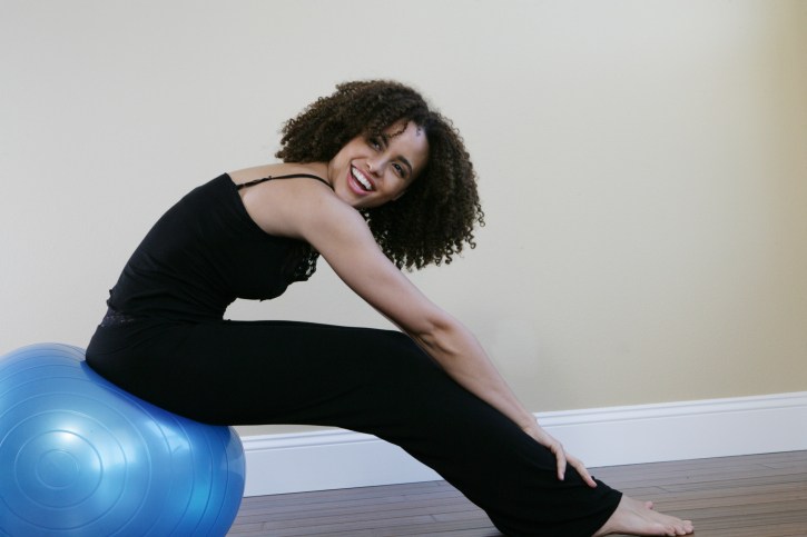 smiling woman sitting on workout ball