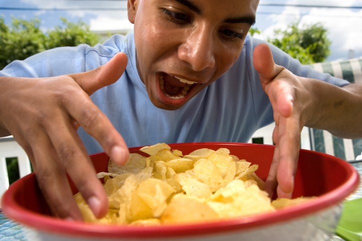 hungry man trying to get a handful of chips