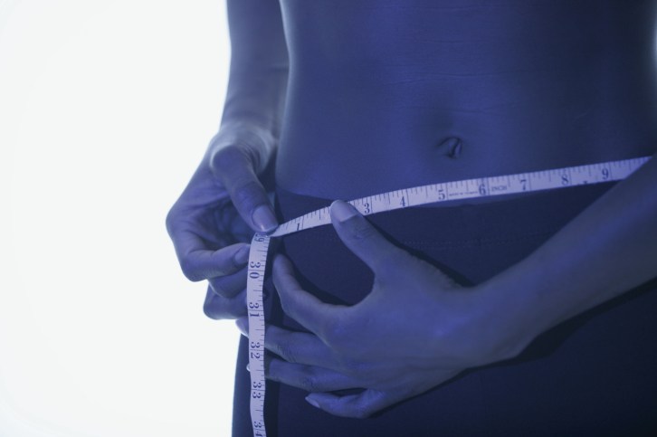 woman measuring her waist