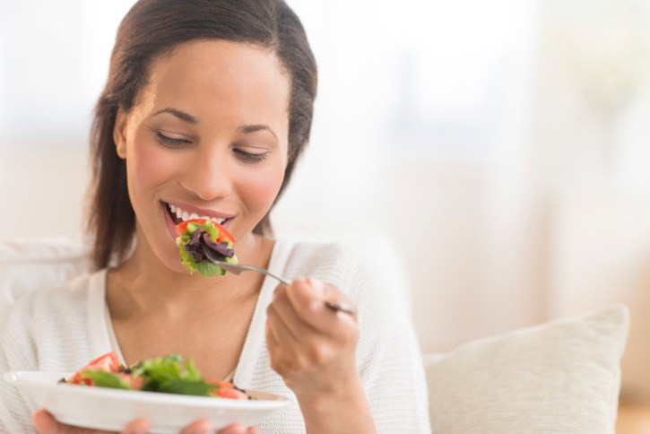 woman at home eating salad