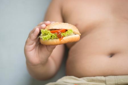 Overweight boy with burger